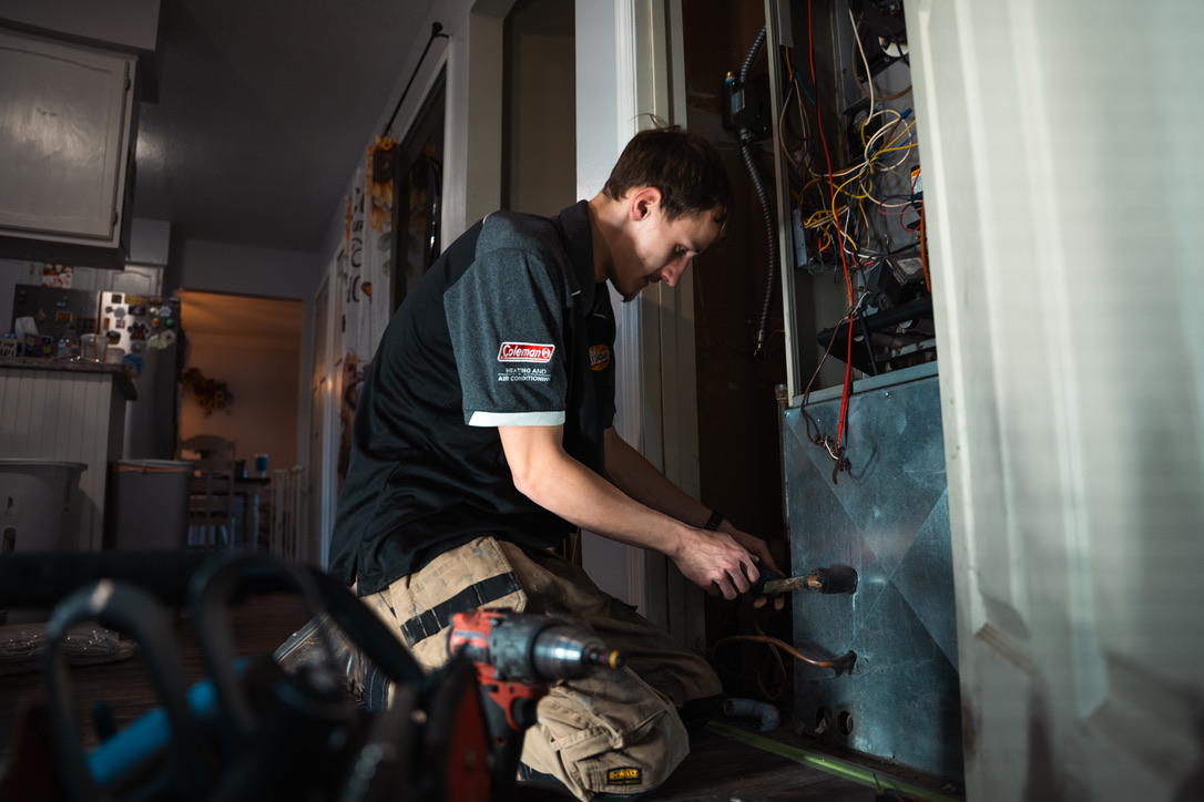 Rick's Affordable technician repairing a furnace inside a customer's home